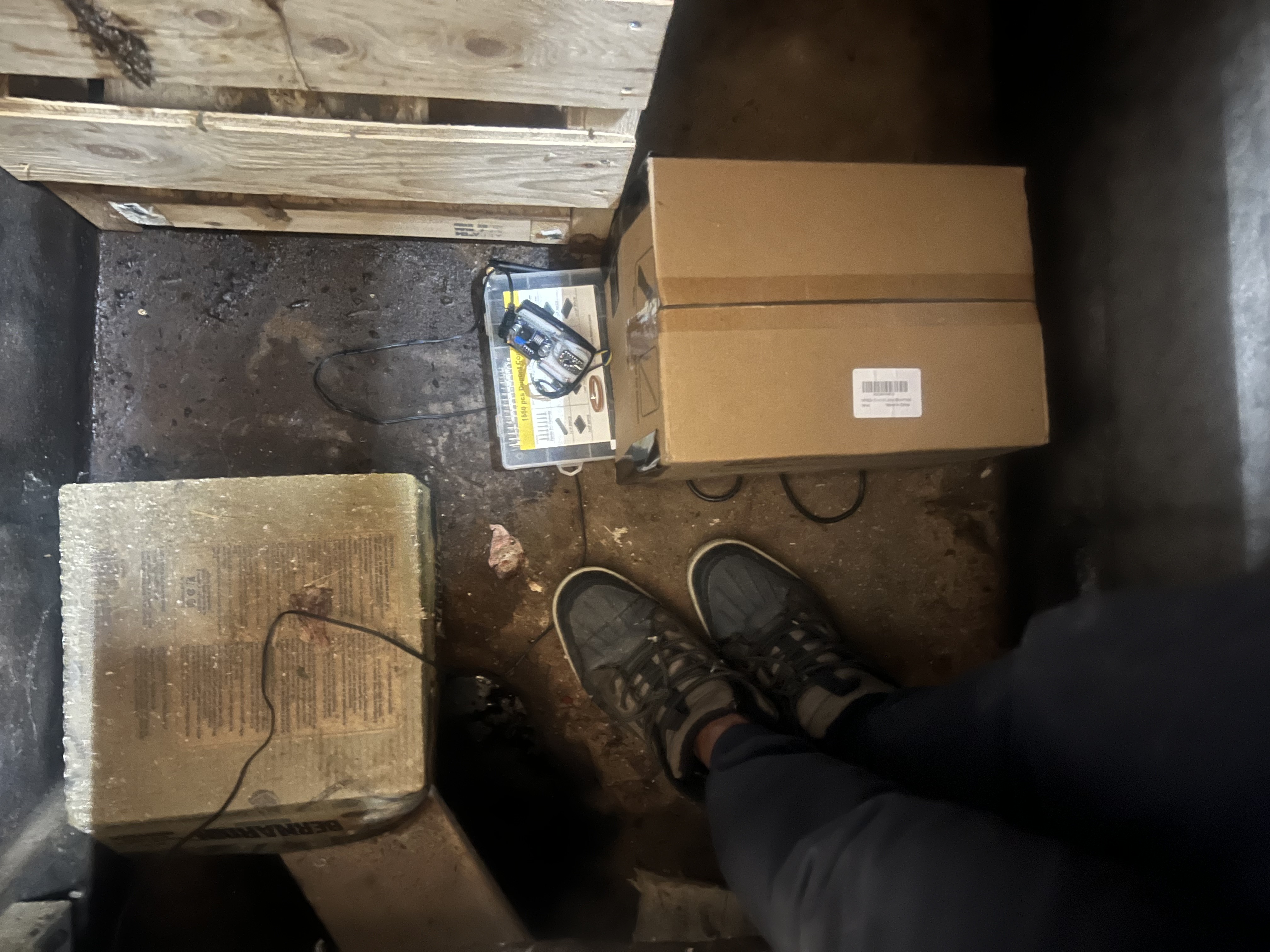 Bottom of pit showing steel bar sensor assemblies and ESP32 electronics enclosure deployed in-situ