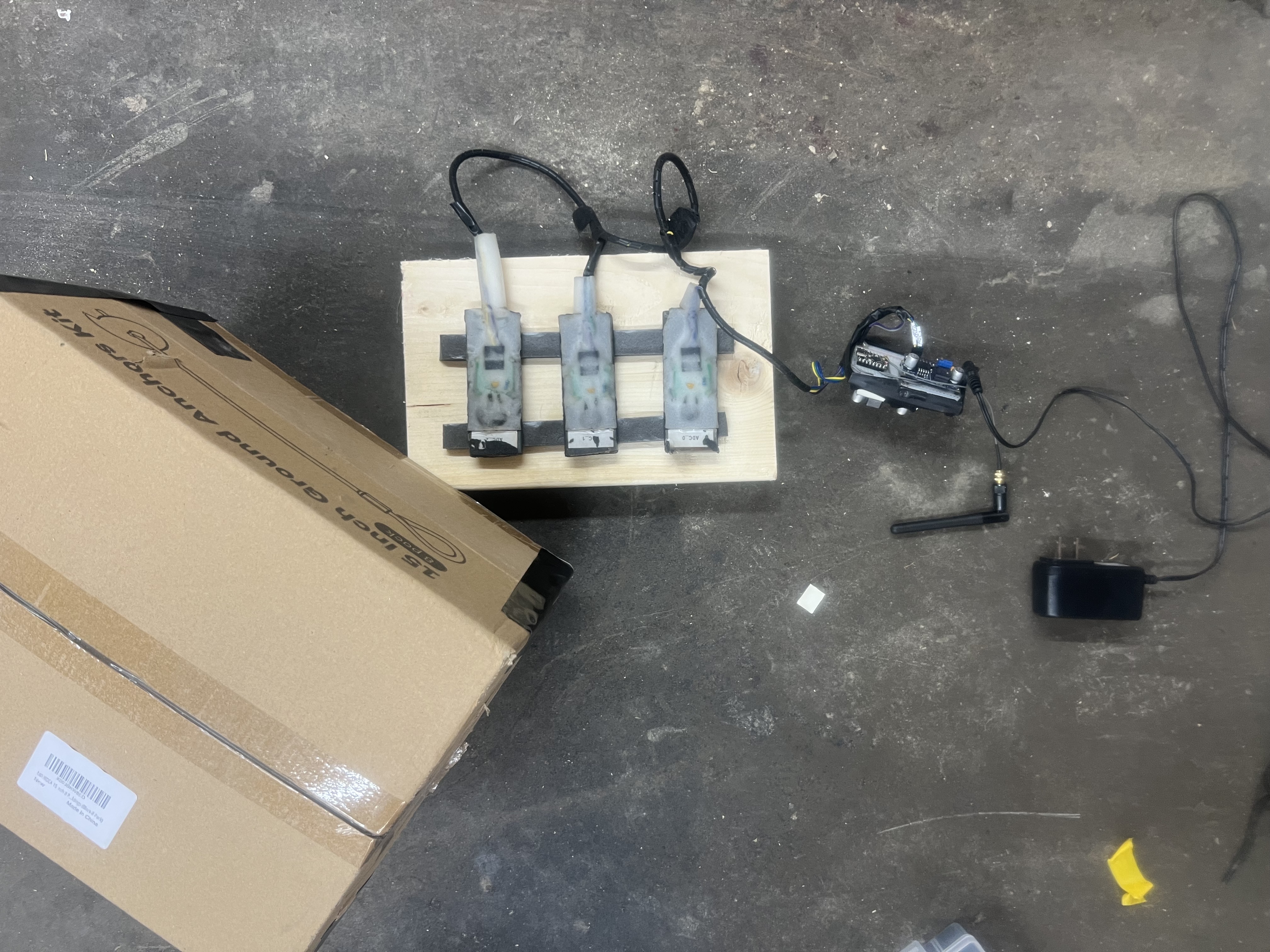 Three NTC sensor assemblies on wooden mount with ESP32-C3 — bench setup during calibration